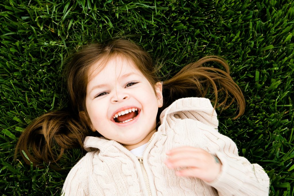 A toddler enjoying a photo session outdoors, capturing a joyful moment.