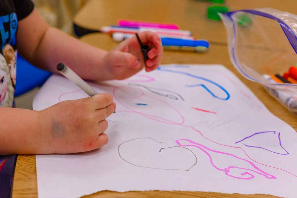 A preschool child in a childcare photography session in a classroom.