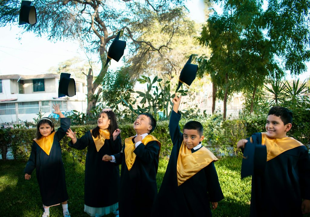 School portrait of students celebrating graduation with gowns at a school ceremony.