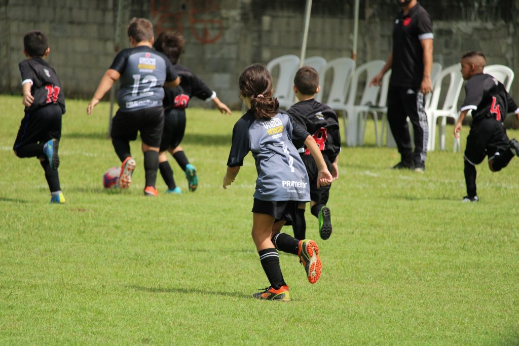 Professional sports team photographer capturing children for a fun football match.