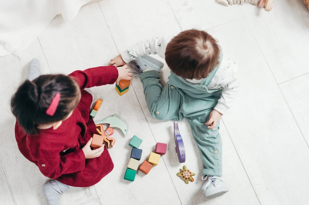 Two young children playing with wooden toys, photographed by child care photographers Sydney.